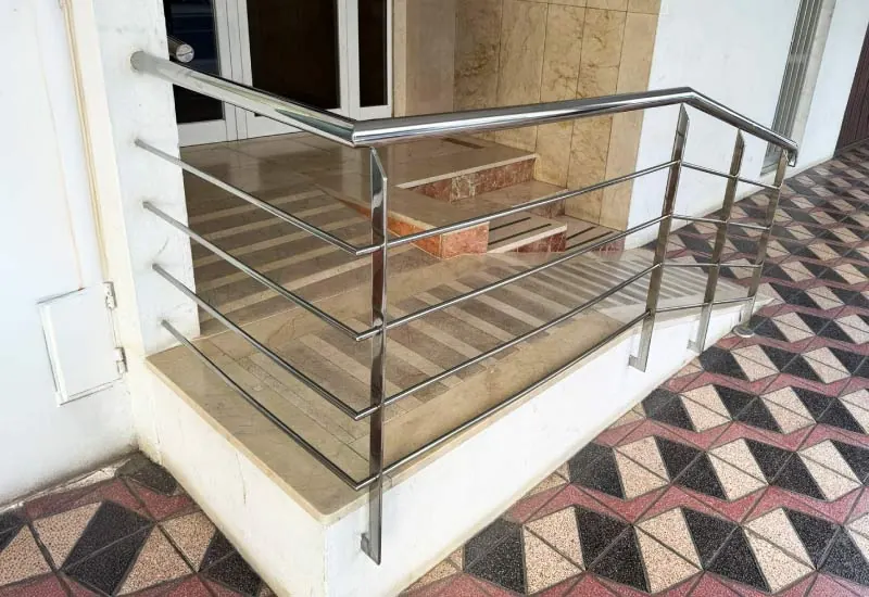 Barandilla de acero inoxidable en la escalera de entrada de una casa