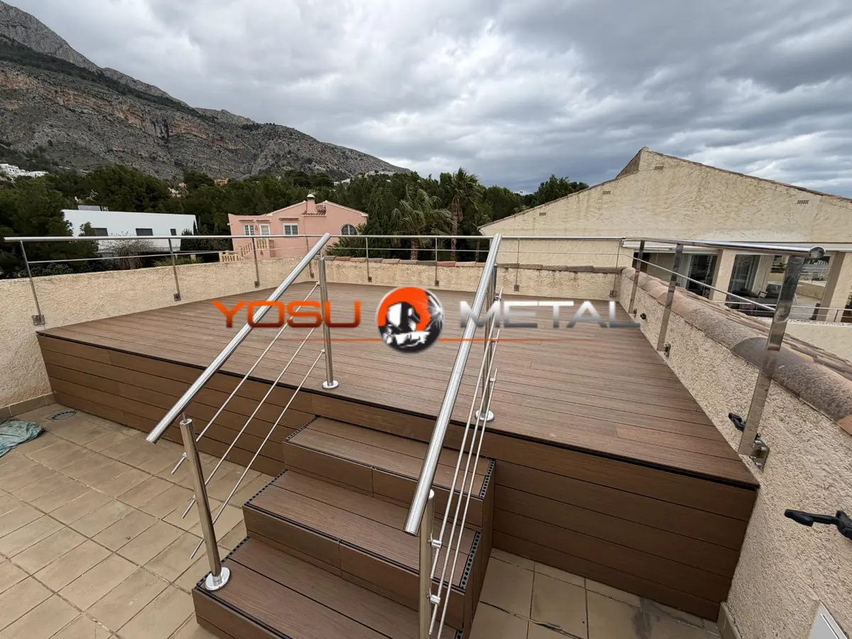 Barandilla de acero inoxidable con varillas en una terraza con escalones, con la montaña al fondo